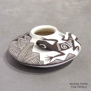 Lizard, fine line and geometric design on a miniature black and white jar