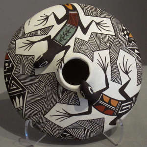 Raised lizard heads and geometric design on a polychrome seedpot