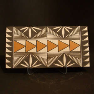 Floral and geometric design on both sides of a polychrome tile