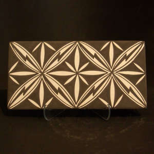 Floral design on both sides of a black and cream tile