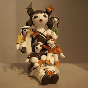 Four children with birds and butterflies on a storyteller figure