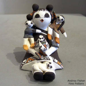 Two children, a cat, a bird and butterflies on an Acoma storyteller