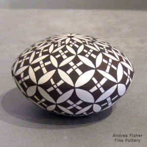 Pumpkin seed and geometric design on a black and white seed pot