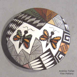 Butterfly and geometric design on a polychrome seed pot
