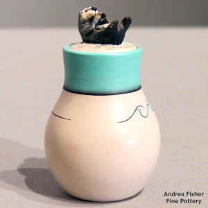 An otter lid and a wave geometric design on a miniature polychrome jar