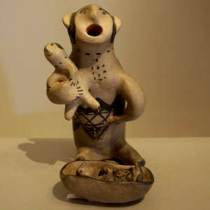 Child in the arms of a singing man with a second child in a crib