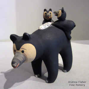 Bear carrying 2 cubs and a fish