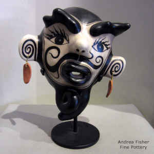 A black and white mask with a circus performer tattoo design and a custom stand