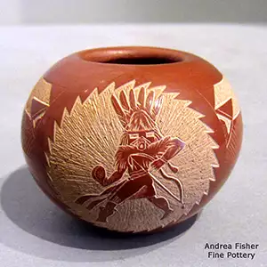 A sgraffito masked dancer and geometric design on a small red jar