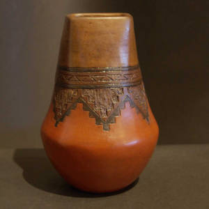 Long neck on a brown jar decorated witha Dineh rug design