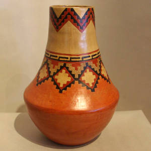 A band of Dineh rug design around the neck of a brown jar