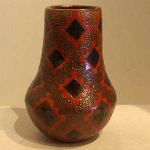 Dineh rug design on a tall brown jar