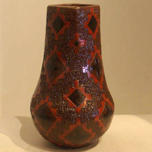 Dineh rug design on a tall neck brown jar