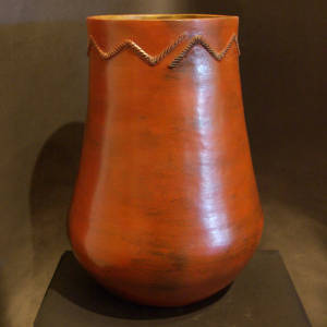 Rope biyo' around the neck of a tall brown jar