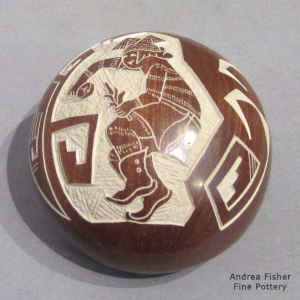 A sgraffito dancer and geometric design on a brown seed pot