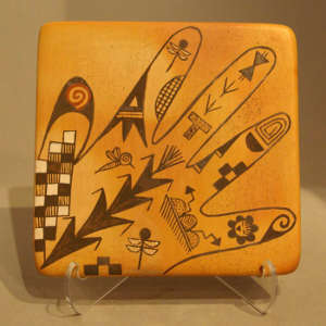 Hand, dragonfly and geometric design on a tile