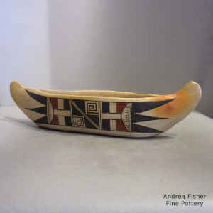 Bat wing and geometric design on a polychrome canoe