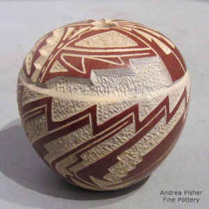 Miniature red on salmon seed pot with lightly carved and sgraffito geometric design