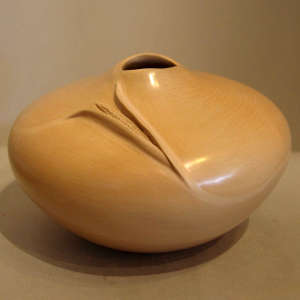 Carved ear of corn and organic opening on a polished tan jar