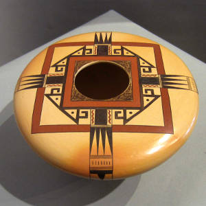 Four direction red and black bird element and geometric design plus fire clouds on a flat-top yellow ware jar