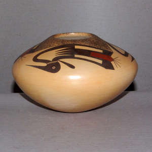 Three stylized ducks decorate a polished buff jar