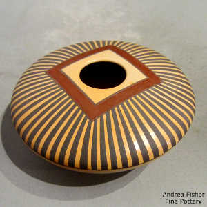 Black and red geometric design on a yellow ware seed pot