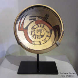 Polychrome bowl with a spiral, rain bird and geometric design inside and a geometric design outside