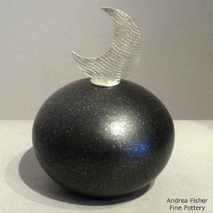 A sterling silver lid on a micaceous black seedpot