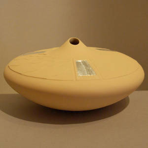 Three sterling silver inlays on a lightly carved yellow ware seed pot with an organic opening