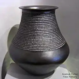 Micaceous black jar with a rolled lip and a wide band of corrugation around the neck
