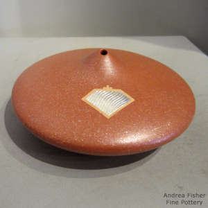 An organic opening and inlaid sterling silver on a red micaceous flying saucer pot