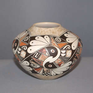 Stylized hawk and shard design on a polychrome white jar