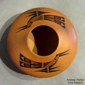 Red micaceous slip on the bottom and a bird element and geometric design above on a polychrome yellow ware jar