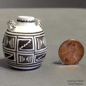 Handles and geometric design on a miniature black and white jar
