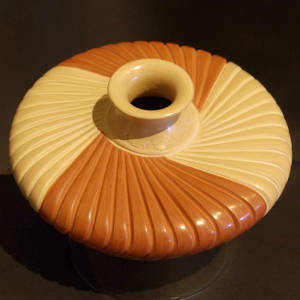 An etched and flared neck tops this red and buff colored carved melon jar