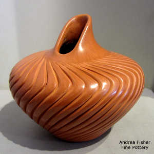 Melon design carved into a red jar with an organic opening