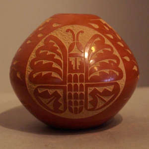 Sgraffito butterfly and geometric design on a red jar