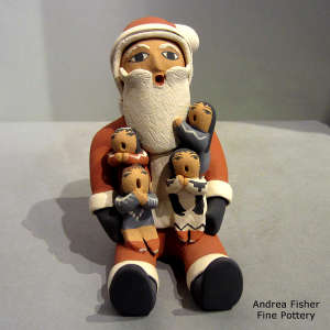 4 children on a Santa Claus storyteller figure