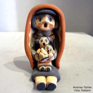 Two children on a grandmother storyteller in a manta