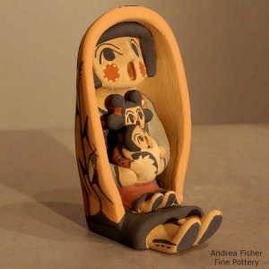 2 children on a grandmother storyteller wearing a manta