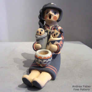 Two chidren on a grandmother storyteller with a twisted hair braid