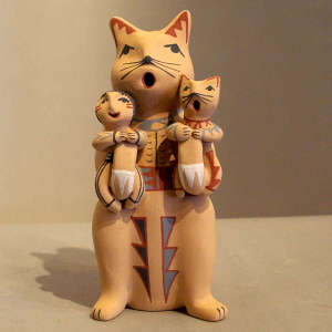 A kitten and a child on a feline storyteller figure