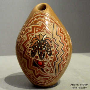 A sgraffito and painte3d ears of corn and geometric design on a polychrome seed pot with an inlaid garnet