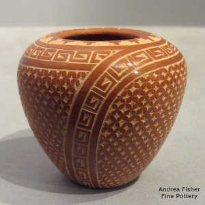 Sgraffito geometric design on a polished red jar