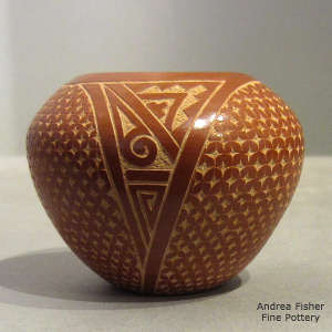 Sgraffito geometric design on a polished red jar