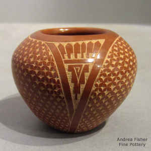 Sgraffito geometric design on a miniature red jar