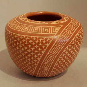 Sgraffito geometric design on a polished red jar