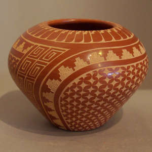 Sgraffito geometric design on a polished red jar