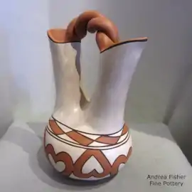 A polychrome wedding vase with a heart and fret geometric design and a twisted handle