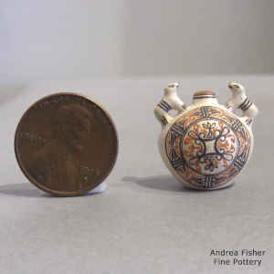 A miniature polychrome canteen with bear handles and a geometric design